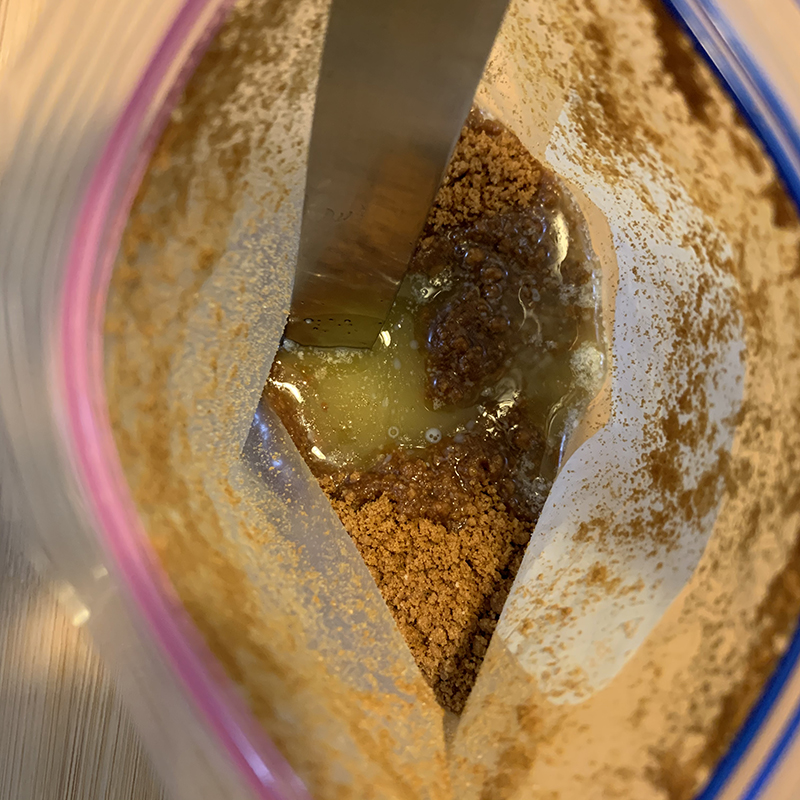 砕いたクッキーに溶かしバターを混ぜる